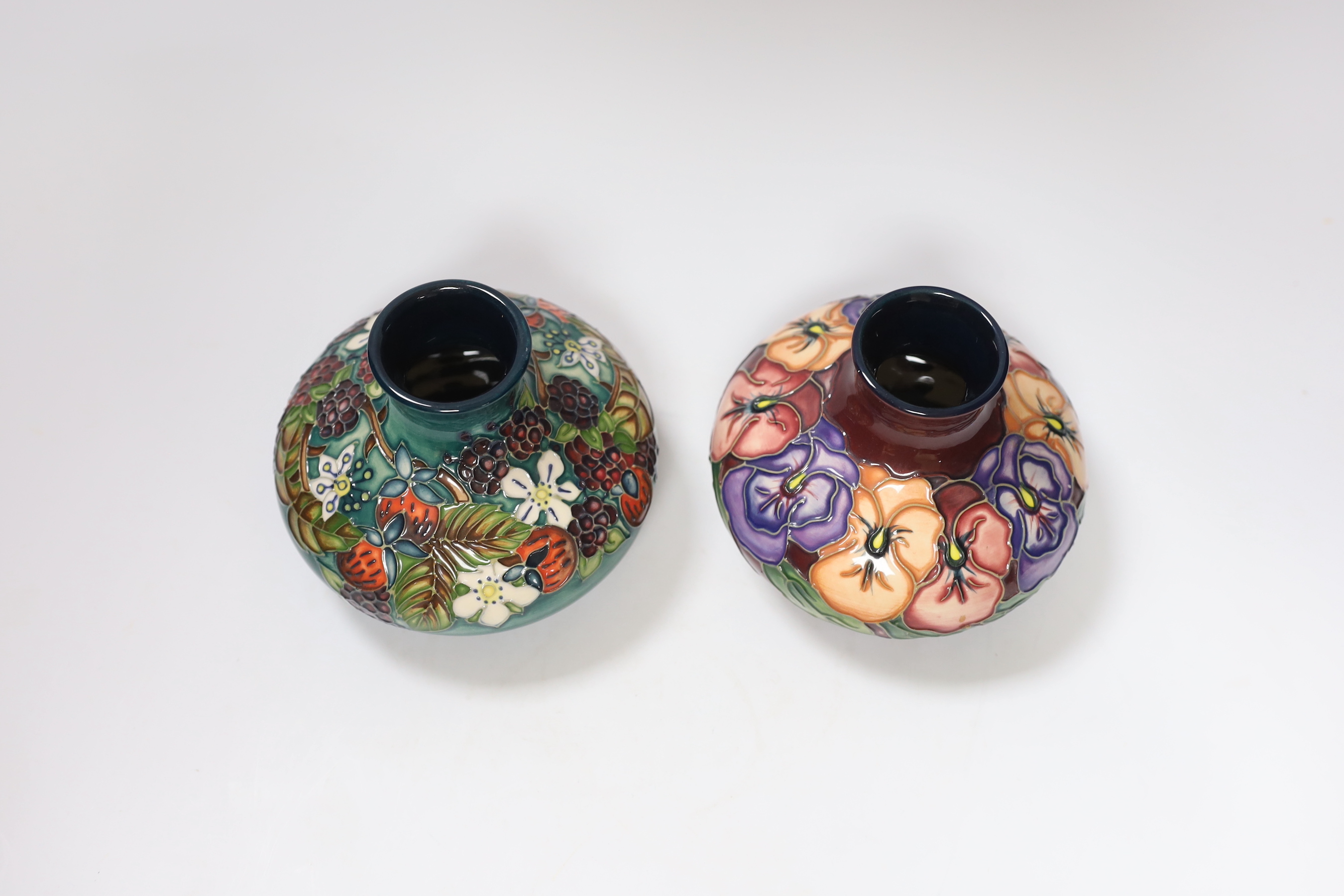 Two small Moorcroft squat vases, in Pansy and Carousel patterns, 10.5cm